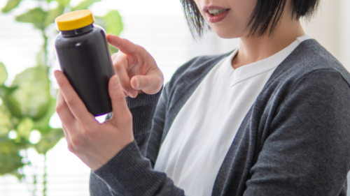 サプリメントの入れ物をもつ女性