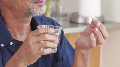 薬を飲もうとする男性